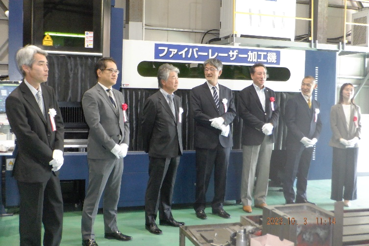 ファイバーレーザー加工機の前に並ぶメーカー・協力会社の関係者