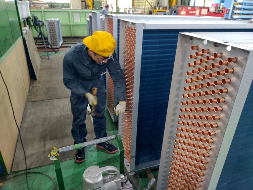 熱交換器コイルの銅管を1本ずつ丁寧に広げる拡管作業の様子